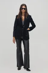 Blazer negro de pana gruesa con lurex plateado, corte boxy, cierre de un botón, bolsillos frontales y mangas largas.