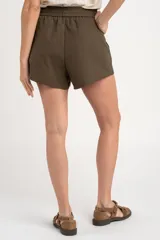 Short negro de lino con cintura elástica fruncida y cordón ajustable del mismo tono. Cuenta con bolsillos laterales.