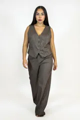 Chaleco de corte sastrero en color marrón con textura jaspeada, presenta escote en V, cierre frontal con botones y bolsillos laterales decorativos.