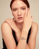 Pulsera rígida plateada con forma de espiral y terminaciones redondeadas.