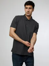 Chomba de manga corta Calvin Klein, confeccionada en mezcla de algodón y poliéster. Presenta cuello clásico, cierre frontal de dos botones y el monograma de la marca bordado sutilmente en el pecho.