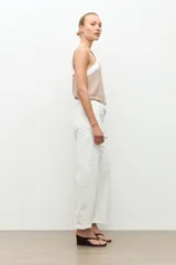 Jean barrel color blanco, de tiro alto y corte relajado con piernas curvas, estilo cropped y presillas en la cintura.