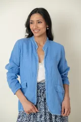 Blazer celeste de lino con corte recto, cuello mao y aplique desflecado en cuello y ruedo.