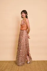 Pollera larga de malla bordada con lentejuelas y diseño de flores, con forro interno satinado y abertura lateral.