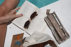 Necessaire transparente de PVC con cierre y bordes en color beige, ideal para guardar artículos pequeños de maquillaje o cuidado personal.