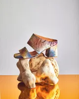 Sandalias de tacón alto con diseño de dos tiras anchas, confeccionadas en tela con estampado abstracto en tonos dorados y negros. Presentan un tacón cuadrado forrado en el mismo tejido.