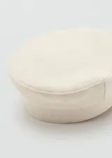 Gorro tipo marinero color blanco off-white, con visera corta y estructura rígida en la parte superior.