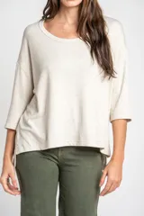 Remera color arena con efecto melange, de corte oversize, cuello redondo y mangas 3/4.