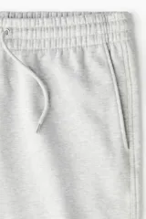 Pantalón deportivo en felpa pesada de mezcla de algodón con interior cepillado suave. Modelo de corte holgado con cintura elástica revestida, cordón de ajuste y bolsillos laterales.