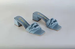 Sandalias tipo sueco color amarillo, con taco ancho y aplique de cadena en el empeine.