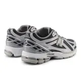 Championes New Balance modelo 1906R, de estilo running retro, color negro y gris con detalles plateados.