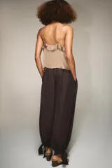 Pantalón de tiro medio con cintura elástica ajustable mediante cordones. Presenta un diseño de pernera abullonada con puños ajustables mediante lazos en los tobillos y bolsillos laterales ocultos en las costuras.