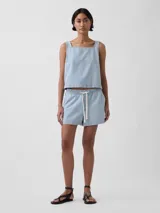 Short jogger de diseño rayado en tonos celeste y blanco, con cintura elástica ajustable mediante cordón y bolsillos laterales.