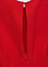 Vestido midi de corte evasé en color rojo, con cuello redondo, sin mangas y tirantes anchos. Presenta un diseño con pinzas en la cintura y cierre posterior con cremallera y botón.