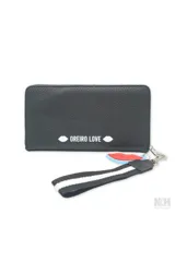 Billetera celeste con cierre de cremallera y estampa con la frase "Mon Amour" en rojo. Incluye correa de mano. Marca Las Oreiro.