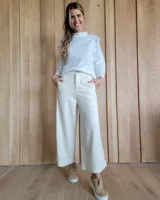 Pantalón color crudo, de corte amplio, con bolsillos laterales y terminación con dobladillo.