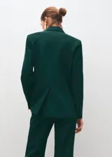 Blazer de corte recto y diseño estructurado, confeccionado en tejido mezcla de lana color verde oscuro. Presenta cuello con solapas de muesca, cierre frontal de doble botonadura, bolsillos de solapa laterales y bolsillo de ribete en el pecho. Incluye forro interior y mangas largas con puños abotonados.