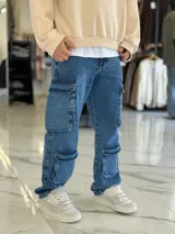 Pantalón de jean estilo cargo, color azul, de corte ancho y holgado, con múltiples bolsillos laterales en muslos y pantorrillas.