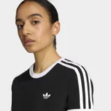 Remera Adidas de corte ajustado, color negro con cuello y bordes de mangas en blanco. Presenta las icónicas tres tiras blancas en los hombros y el logo del trébol bordado en el pecho.