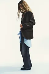 Blazer oversize de corte recto con estampado de raya diplomática. Presenta cuello con solapa, cierre frontal cruzado con botones, hombros caídos y bolsillos delanteros con vivo.