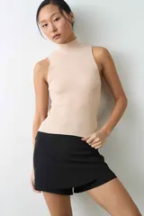 Musculosa de punto rib color beige, con cuello alto y diseño ajustado al cuerpo.