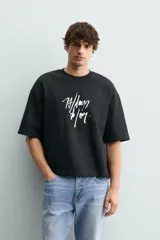 Sudadera de corte relajado confeccionada en algodón, con cuello redondo, manga corta y acabado en rib. Presenta un estampado gráfico a contraste en la parte frontal.