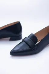 Mocasines negros de cuero con punta fina y detalle de antifaz.