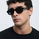 Lentes de sol negros con montura cuadrada de bordes redondeados.