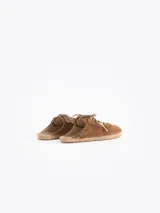 Slide estilo alpargata confeccionado en cuero descarne color celeste, con cordones beige, detalles de flecos y dijes colgantes, sobre una base de yute trenzado.