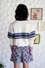 Short unisex de corte holgado con cintura elástica y estampado a cuadros rojos y blancos con dibujos de frutas.