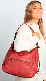 Cartera de hombro color negro, confeccionada en material símil cuero con textura granulada. Presenta un diseño estructurado con cierre superior, bolsillo frontal con cierre horizontal, bolsillos laterales con cierre y herrajes metálicos. Incluye una correa de hombro fija y una correa larga regulable extraíble.