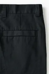 Pantalón sastrero color negro de corte relajado, confeccionado en mezcla de algodón y lyocell, con pliegues frontales y bolsillos laterales.