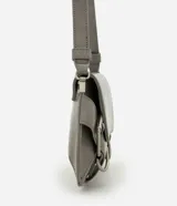 Cartera modelo baguette de tamaño pequeño, con formato estructurado, tapa delantera y detalles de hebillas decorativas. Cuenta con asa para hombro e interior forrado con compartimento.
