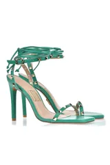 Sandalias de tacón alto color verde con tiras finas y apliques de tachas doradas.