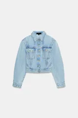 Cazadora corta de denim color celeste con cuello solapa, manga larga y hombreras. Cuenta con bolsillos delanteros con solapa y cierre frontal de botones metálicos.