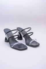 Sandalias plateadas con taco de forma geométrica y tiras transparentes.