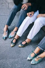 Zapato tipo blucher de cuero con acabado metalizado en color azul petróleo y estampado de estrellas blancas. Presenta un diseño con flecos decorativos en la parte frontal, cierre con cordones y suela plana de cuero.