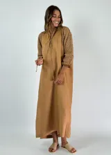 Vestido largo color ocre con mangas largas de crochet y cuello con cordones.