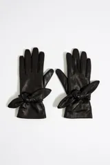 Guantes de piel color negro con detalle de lazo en la muñeca.