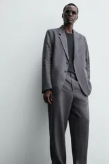 Pantalón de traje regular fit confeccionado en tejido de lino, con cierre frontal de cremallera y botón, bolsillos laterales y bolsillos traseros de vivo.
