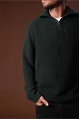 Sweater verde oscuro de punto con cuello alto y cierre de cremallera parcial. Tejido de canalé vertical.