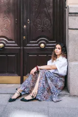 Botines bajos negros con diseño tejido y cordones con borlas. Presentan detalles de animal print en el tobillo y ribete ocre.