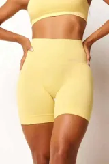 Conjunto deportivo de top y short seamless color amarillo, confeccionado con textura canelada y tecnología sin costuras. El top presenta diseño minimalista y el short incluye cintura alta y efecto push up.