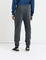 Pantalón jogging de tejido circular con cintura elástica y cordón ajustable. Presenta puños elastizados en el ruedo y bolsillos laterales.