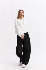 Blusa de corte relajado y fit holgado, con mangas largas amplias y textura sutil. Presenta un diseño minimalista con caída suave.