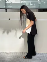 Remera de corte amplio con mangas cortas y diseño a bloques de color: negro en la parte superior, marrón anaranjado en el centro y blanco en la parte inferior.