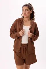 Conjunto de dos piezas compuesto por un buzo con capucha y cierre frontal, y un short a juego. El buzo presenta mangas largas con puños elásticos y bolsillos frontales, mientras que el short cuenta con cintura elástica y cordón ajustable. Confeccionado en tela suave y liviana.