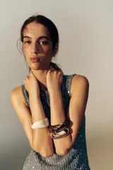 Pack de tres pulseras rígidas de diferentes formas y tamaños: una en tono marfil jaspeado, una dorada metálica brillante y otra oscura efecto carey.