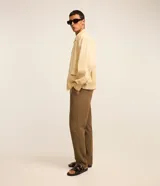 Campera color beige claro de algodón con textura arrugada, cuello inglés, cierre con cremallera, bolsillos laterales, elástico en la cintura y puños.