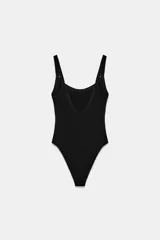 Body de cuello cuadrado con tirantes finos, confeccionado en tejido elástico con cierre inferior mediante botones a presión.